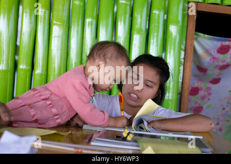 Myanmar (Birmania). Lago Inle. Un bambino di 18 mesi baby imparare a scrivere. Foto Stock