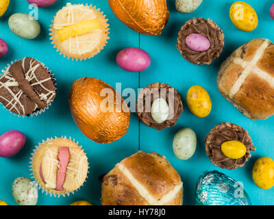 Selezione di tradizionali torte di pasqua e mini uova di pasqua di cioccolato contro uno sfondo blu Foto Stock