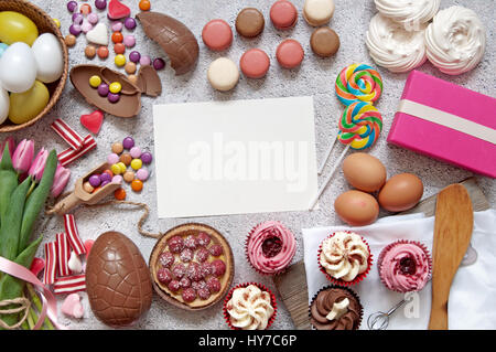 Selezione di Dolci pasquali, panetteria, tortini di uova di cioccolato e pasticceria con un pezzo di carta nel centro Foto Stock