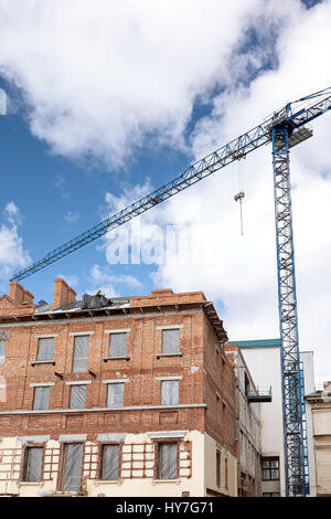 Edificio della città durante i lavori di ristrutturazione sul cielo blu sullo sfondo Foto Stock