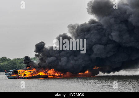 Medan, nel nord di Sumatra, Indonesia. 2 apr, 2017. I detriti con fumo nero volare in aria come un peschereccio straniero è stato soffiato da militari indonesiani dalle acque di Belawan a Medan, Provincia del Nord Sumatra, il 1 aprile 2017, Indonesia. Il naufragio di sabato tenuti contemporaneamente in dodici diverse ubicazioni in tutto il paese e supervisionato da militari indonesiani e di polizia come autorità blew up ed affondò 81 barche da pesca nelle acque sgattaiolò fuori della caccia. Questo porta il numero totale di navi sequestrati e distrutti a 317 dall'ottobre 2014 quando il presidente di Joko Widodo s Foto Stock