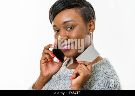 Una donna africana usa un cellulare in un ambiente studio. Foto Stock