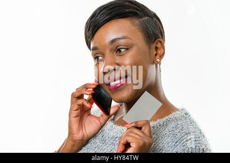 Una donna africana usa un cellulare in un ambiente studio. Foto Stock