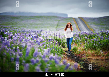 Felice fiducioso delle giovani donne in un campo di fiori viola nel sud dell'Islanda Foto Stock