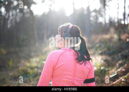 Una donna si prepara per andare a correre nei boschi Foto Stock