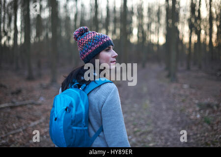Una donna in un paese a piedi nei boschi Foto Stock