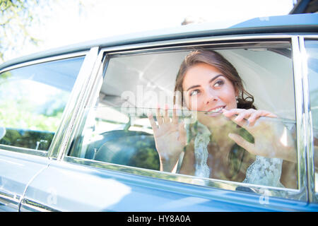 Una sposa si siede in auto nozze dopo il matrimonio Foto Stock