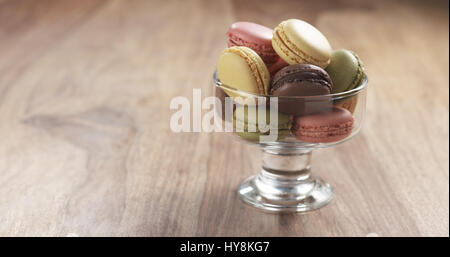 Macarons misti in recipiente di vetro su tavola, 4k foto Foto Stock