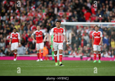 Dell'Arsenal Alexis Sanchez (centro) e compagni di squadra stand sconsolato dopo il Manchester City Sergio Aguero (non raffigurata) punteggi al suo fianco il secondo obiettivo del gioco durante il match di Premier League a Emirates Stadium di Londra. Foto Stock