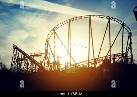 Silhouette di montagne russe al tramonto Foto Stock