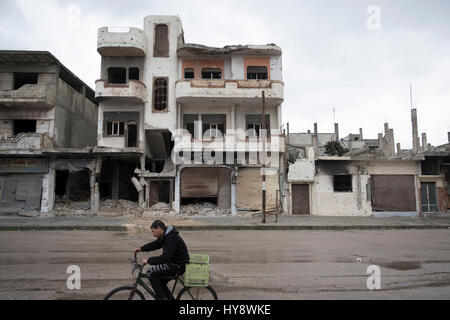 Bicycler in distressed distretto di Baba Amr in Homs, Siria nei primi mesi del 2017 Foto Stock