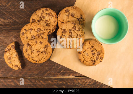 Gocce di cioccolato i cookie su carta da forno, con latte Foto Stock