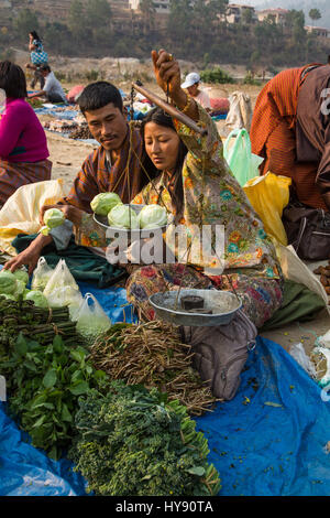 Donna vendita di produrre nel mercato degli agricoltori in Punakha, Bhutan. Foto Stock