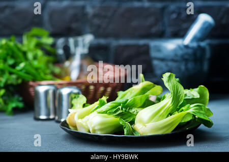 Fresh pak choi sulla piastra e su una tavola Foto Stock