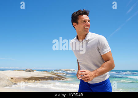 Ritratto di un felice uomo di mezza età di camminare sulla spiaggia Foto Stock