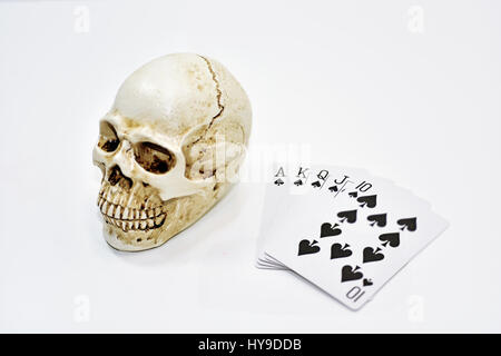 Piccolo decorativo cranio umano con le carte da gioco. Isolato su sfondo bianco. Foto Stock