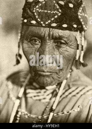 La fotografia di Edward S. Curtis della sua collezione "People 097" cattura un individuo nativo americano in un abbigliamento tradizionale. Curtis è rinomato per documentare la cultura e le tradizioni dei nativi americani durante i primi anni del XX secolo. Foto Stock