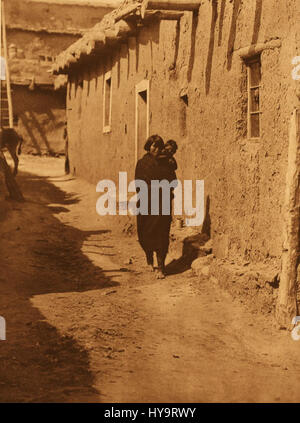 La fotografia di Edward S. Curtis dalla sua collezione "People" cattura la vita dei nativi americani, raffigurando individui in abbigliamento tradizionale. L'immagine riflette l'attenzione di Curtis sulla conservazione delle culture indigene attraverso il suo lavoro fotografico. Foto Stock