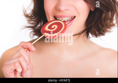 Giovane donna con multi-colore di staffaggio e caramelle. Concetto dentale Foto Stock