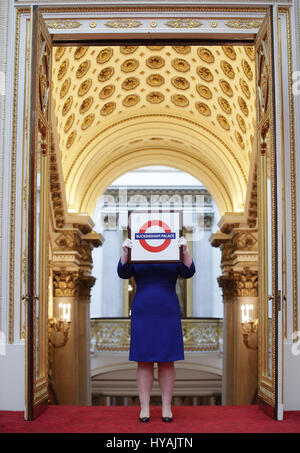 Un membro del personale può contenere un metro di Londra segno presentato alla Regina Elisabetta II durante la sua visita alla stazione della metropolitana di Aldgate East nel 2010, durante un'anteprima per la mostra di Royal doni, che è parte della stagione estiva con apertura delle camere di stato a Buckingham Palace di Londra. Foto Stock
