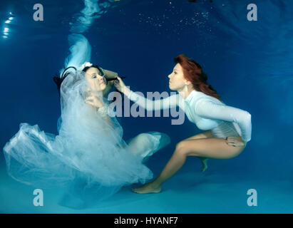 Tutti i round esclusivo. ODESSA, UCRAINA: Sposa Natalia Kol ha il suo make up done. Gli sposi sono letteralmente prendendo il tuffo quando si tratta di commemorare il loro nuovo matrimonio. Jumping in all'estremità profonda, questi bizzarri immagini raccontano la storia del rapporto tra DJ Natalia Kol (26) e il Designer Viacheslav Kol (28) da Odessa, Ucraina, dal corteggiamento al matrimonio - mentre a tre piedi sott'acqua. Le immagini mostrano come lo sposo vince la sposa con una rosa rossa e va in giù su un ginocchio per la grande proposta. Possiamo anche vedere il make-up artist di andare a lavorare sul grande giorno, come ben come il primo ballo, Foto Stock