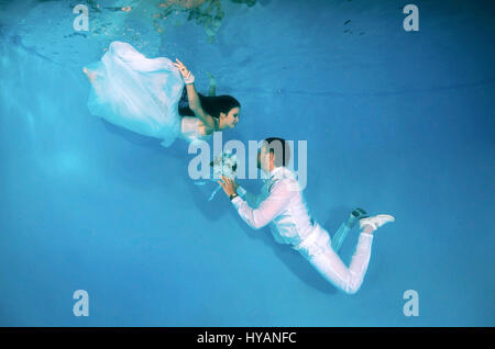 Tutti i round esclusivo. ODESSA, Ucraina: la sposa e lo sposo aventi il loro primo ballo. Gli sposi sono letteralmente prendendo il tuffo quando si tratta di commemorare il loro nuovo matrimonio. Jumping in all'estremità profonda, questi bizzarri immagini raccontano la storia del rapporto tra DJ Natalia Kol (26) e il Designer Viacheslav Kol (28) da Odessa, Ucraina, dal corteggiamento al matrimonio - mentre a tre piedi sott'acqua. Le immagini mostrano come lo sposo vince la sposa con una rosa rossa e va in giù su un ginocchio per la grande proposta. Possiamo anche vedere il make-up artist di andare a lavorare sul grande giorno, come ben come il primo danc Foto Stock