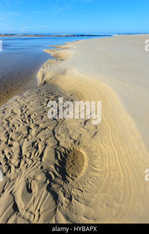 Modelli di sabbia dove il lago Conjola incontra il mare in spiaggia Conjola, Shoalhaven, South Coast, Nuovo Galles del Sud, NSW, Australia Foto Stock