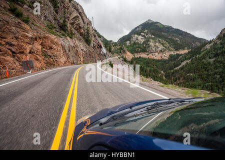 Auto guidando in salita su una strada di montagna delle montagne rocciose, Colorado, STATI UNITI D'AMERICA Foto Stock
