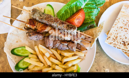 Viaggio in Medio Oriente paese Regno di Giordania - al di sopra di vista di spiedini con vari arabian kebab in Ristorante nella città di Petra Foto Stock