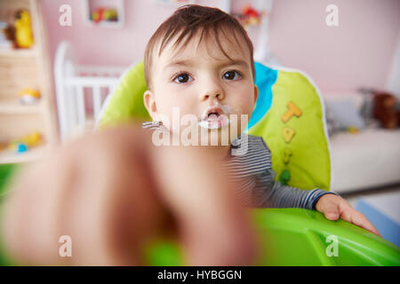 Il Toddler essendo alimentato con yogurt Foto Stock