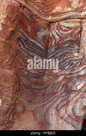 Vene di diverse forme, colori e sfumature su rocce rosse di tombe reali, strutture funerario scavato nella roccia nella città di Petra Foto Stock