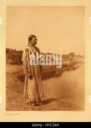 La fotografia di Edward S. Curtis della sua famosa serie "The North American Indian" cattura un individuo nativo americano in un abbigliamento tradizionale. Il lavoro di Curtis mirava a documentare e preservare le culture e i modi di vita dei popoli indigeni all'inizio del XX secolo, spesso in modo romanticizzato o idealizzato. Le sue fotografie rimangono un'importante testimonianza del patrimonio e della storia dei nativi americani. Foto Stock