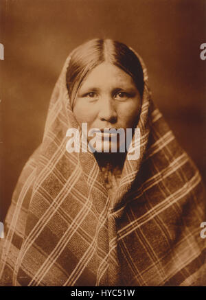 Questa fotografia della collezione di Edward S. Curtis presenta un individuo di nativi americani, che mostra il ritratto dettagliato e rispettoso delle popolazioni indigene nell'America dei primi anni del XX secolo. Foto Stock