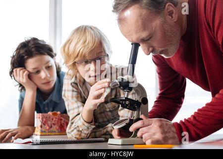 Interessati awesome insegnante avente uno sguardo all'esperimento Foto Stock