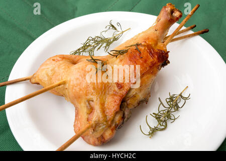 Fatti in casa al forno croccanti rosmarino le cosce di pollo, su sfondo verde, all'aperto Foto Stock