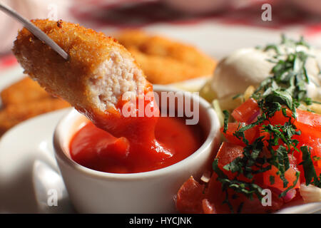 Uomo con gustose varietà Nugget e ciotola con la salsa sul tavolo, primo piano Foto Stock