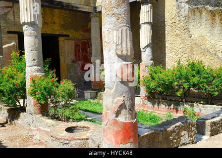 Ercolano. Casa dell'atrio corinzio di Ercolano è denominato così dopo un atrio attorno ad una piccola fontana al centro e sei colonne corinzie intorno al suo perimetro. Le colonne sono fatte di tufo e coperti da marmo stucco. Foto Stock