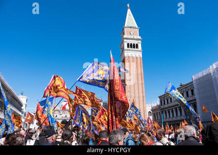 Celebra la festa del santo di Venezia in Piazza San Marco con le bandiere e gli striscioni su una ventilata giornata di sole Foto Stock