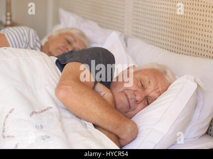 Senior l'uomo e sua moglie dorme nel letto di casa Foto Stock