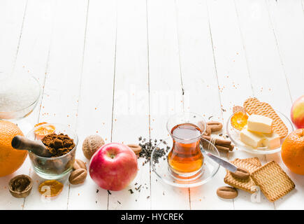 Il tè del mattino con frutta e frutta candita. In legno bianco e di sfondo per il testo. Foto Stock