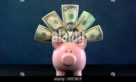 Rosa salvadanaio concetto di denaro su sfondo blu scuro, farcite con usa contanti. Foto Stock