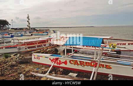 Barche parcheggiato sulla riva con un faro in background, Alaminos Pangasinan, Filippine Foto Stock