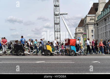 Turisti attraversando Westminster Bridge, vicino al Millennium Wheel, Londra Foto Stock