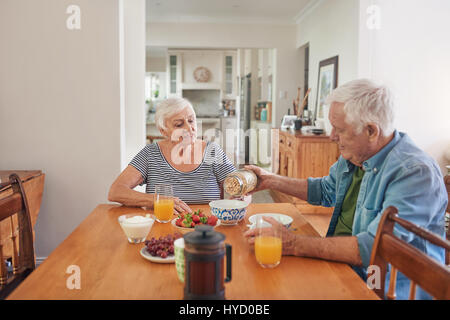 Seniors sorridente godendo di una sana colazione a casa insieme Foto Stock