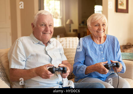 Emozionato coppia senior per giocare con i videogiochi insieme a casa Foto Stock