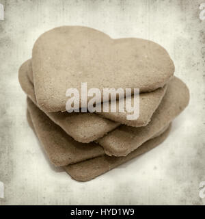 Textured vecchia carta sfondo con ginder cookie sottile conformata come un cuore Foto Stock