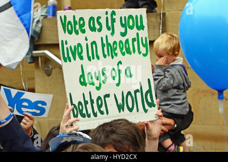 Un piccolo ragazzo e un segno sì fianco un cartello con un messaggio di ispirazione al sì in Scozia nel rally di Glasgow alla vigilia del polling in scozzese referendum di indipendenza Foto Stock