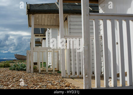 Cabine sulla spiaggia, sulla ghiaia a Pevensey. Foto Stock