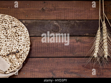 Pasqua sfondo. Matzah fatti a mano (Pasqua ebraica pane) su sfondo di legno. Lay piatto Foto Stock