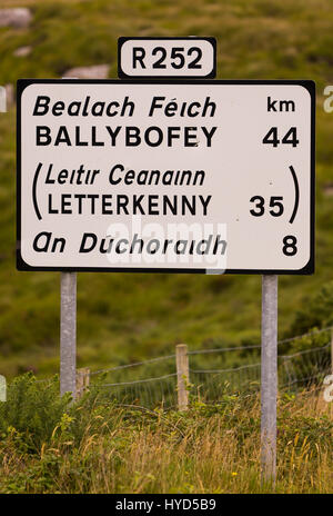 DONEGAL, Irlanda - Autostrada bilngual cartello stradale, in inglese e in gaelico. Foto Stock